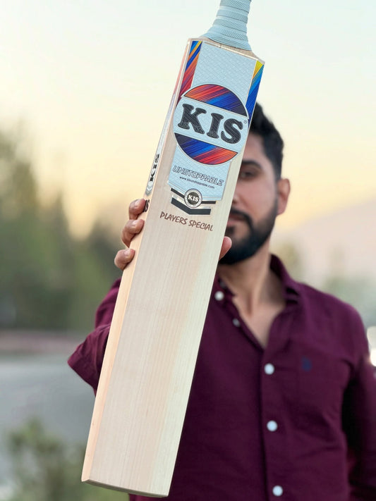 Person holding a players special cricket bat with KIS branding outdoors