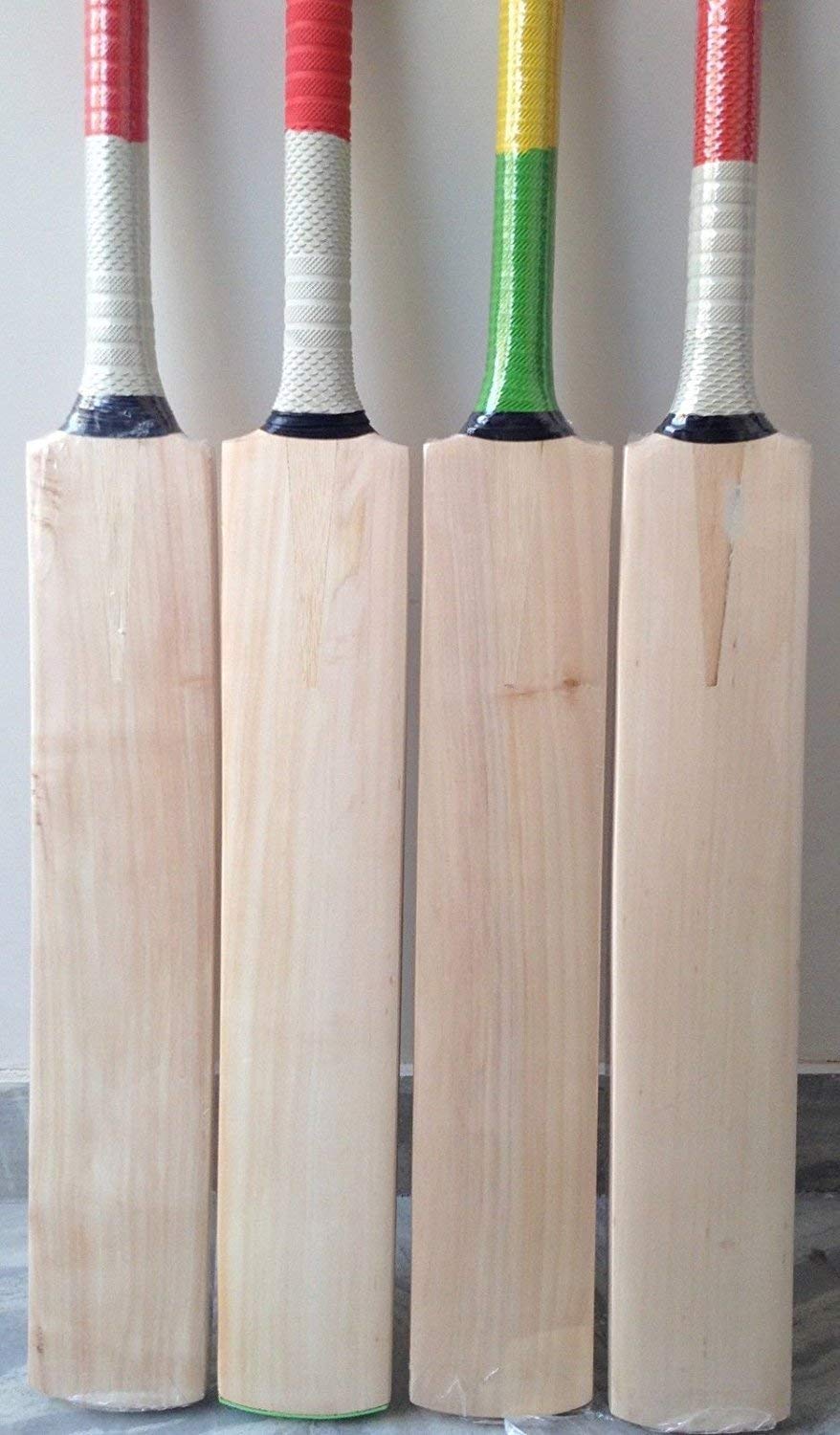 Group of four tennis cricket bats with multi coloured rubber grips. These cricket bats are specially made for hard tennis cricket bat.